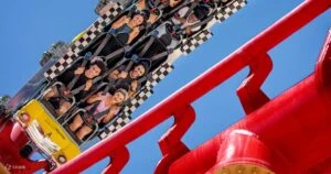 Montaña rusa Las Vegas Big Apple Coaster recorriendo el hotel New York New York con vistas a la Strip y rieles rojos en acción.