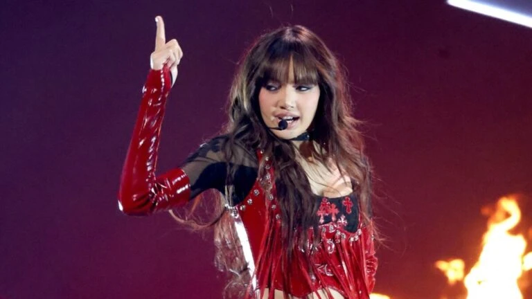 Lisa en concierto de K-pop con vestuario rojo y presentación en vivo sobre escenario con luces intensas