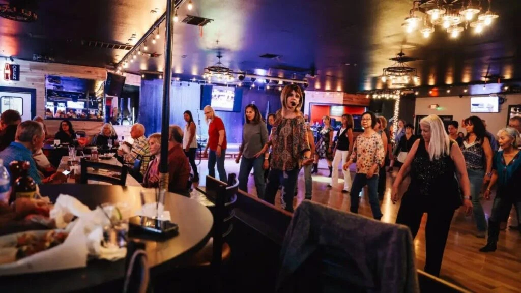 Country bars con música en vivo, line dancing y ambiente honky tonk lleno de asistentes